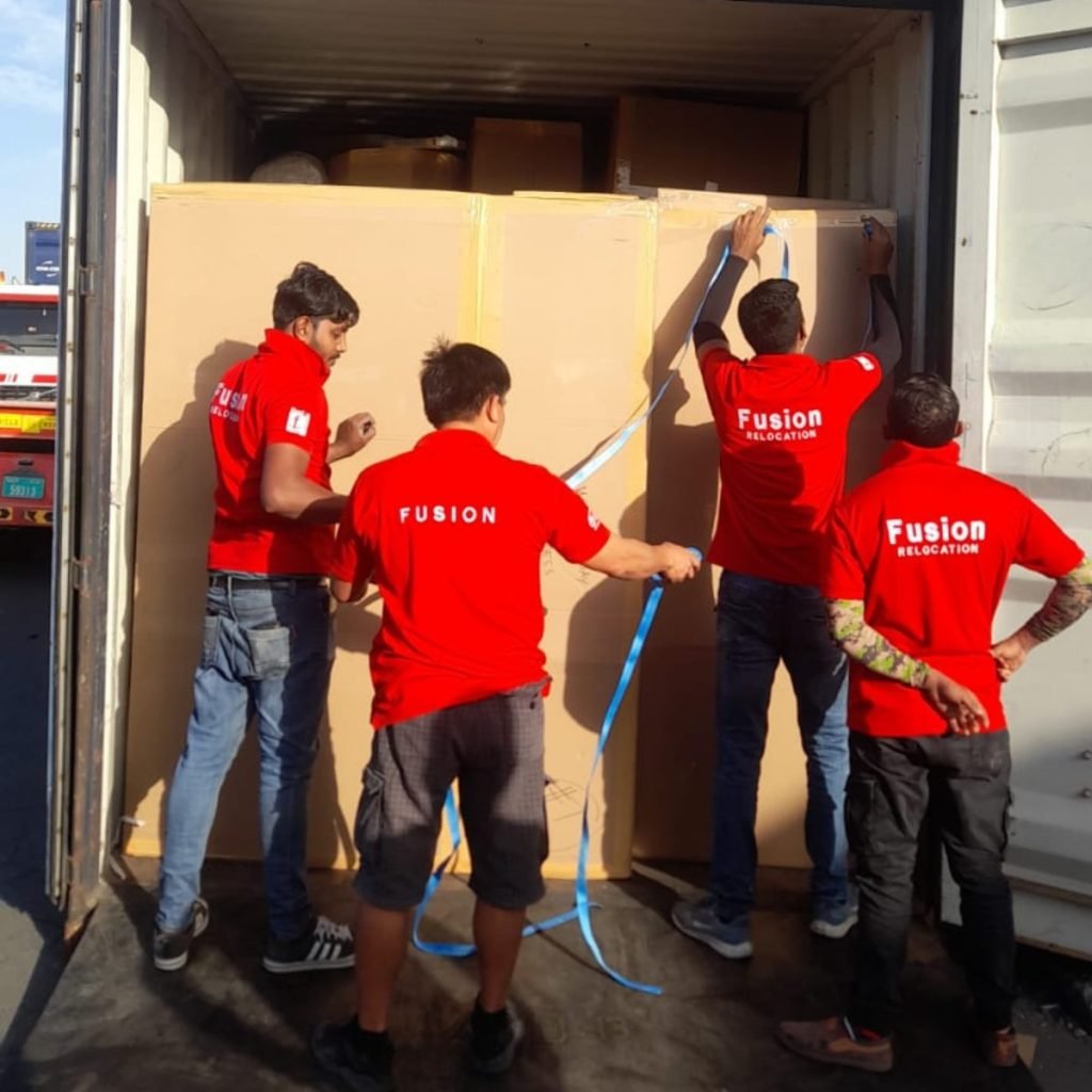 Fusion crew strapping and lashing cartons inside a container at the port