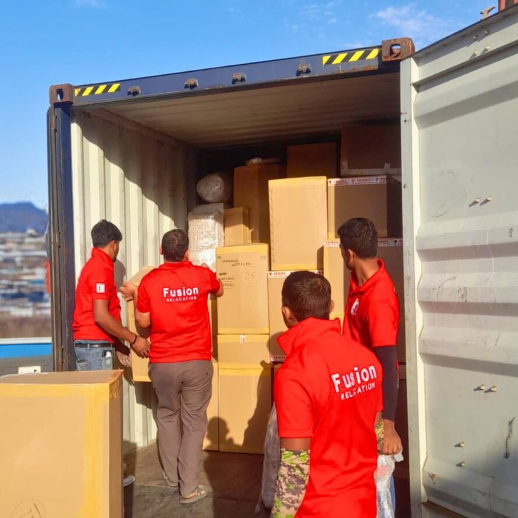 Fusion team loading export cartons into a sole-use container