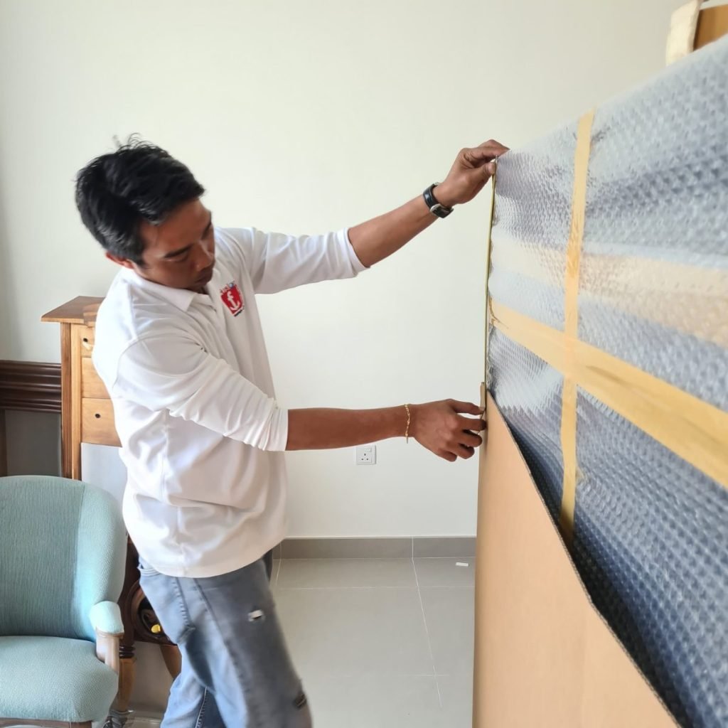 Fusion crew protecting furniture with bubble wrap during an export packing job in a Dubai villa
