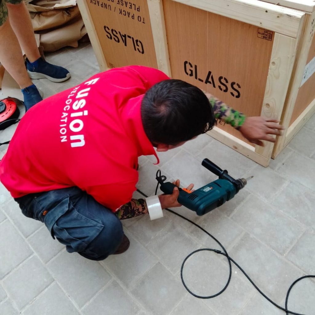 Fusion carpenter closing a custom wooden crate stencilled GLASS