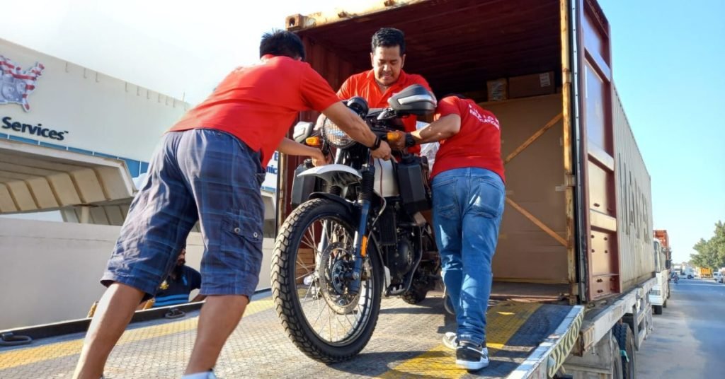 Fusion crew loading a motorbike into an export container