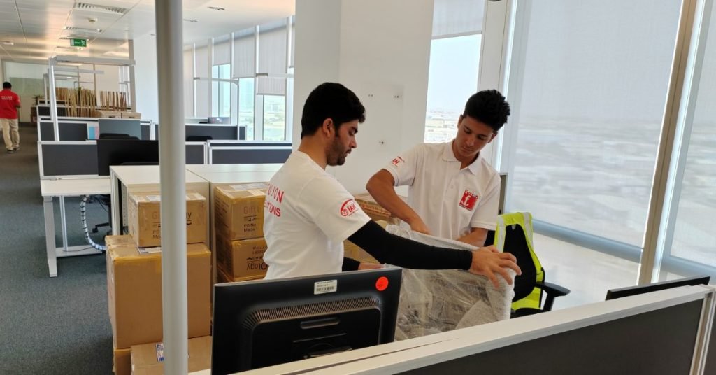 Fusion movers wrapping office chairs and equipment during a commercial move