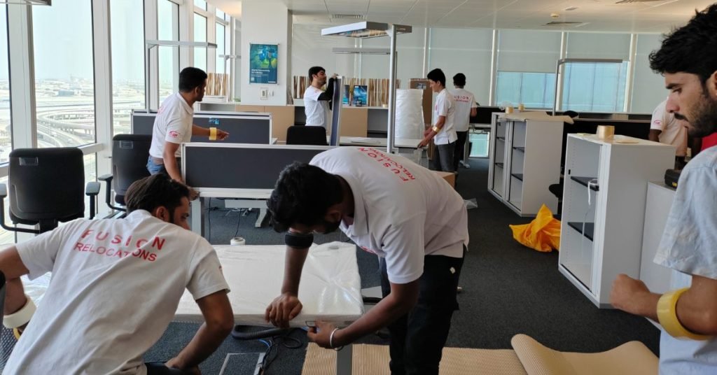 Fusion team packing workstations during an office relocation in a Dubai tower